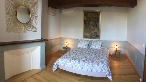 1 dormitorio con 1 cama con 2 lámparas y espejo en La Prévôté, en Marchenoir