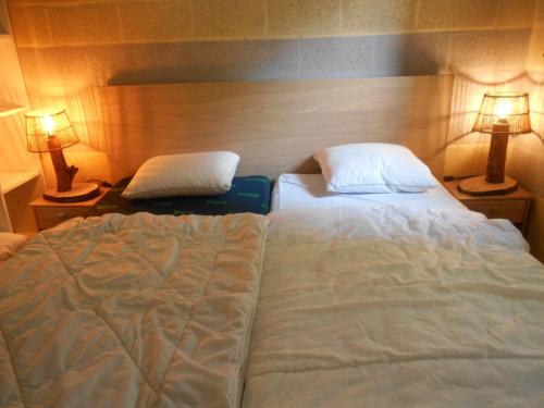 a bedroom with a large bed and two lamps at Le Vieux Sart 3 in Stavelot