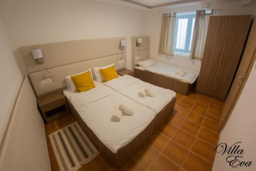 a bedroom with a bed with yellow pillows and a tub at Villa Eva in Gradac