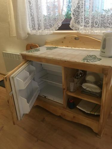 a small cabinet with an open refrigerator in a kitchen at Pokoje Gościnne Koralik in Zakopane