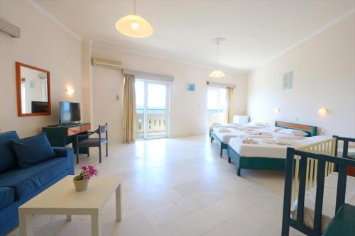 a living room with four beds and a couch at Regina Hotel in Kissamos