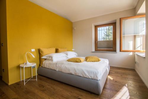 ein Schlafzimmer mit einem Bett mit gelben Wänden und einem Fenster in der Unterkunft CHIARA in Cuneo