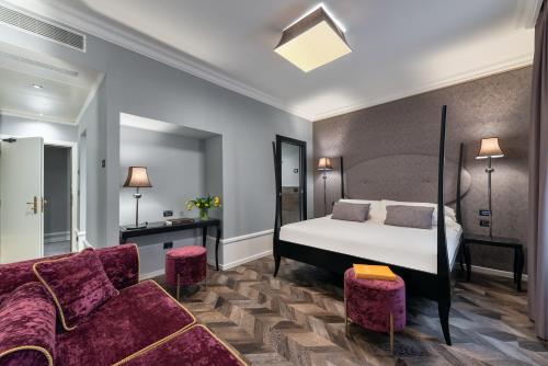 une chambre d'hôtel avec un lit et un canapé dans l'établissement Hotel Milano & SPA***S, à Vérone