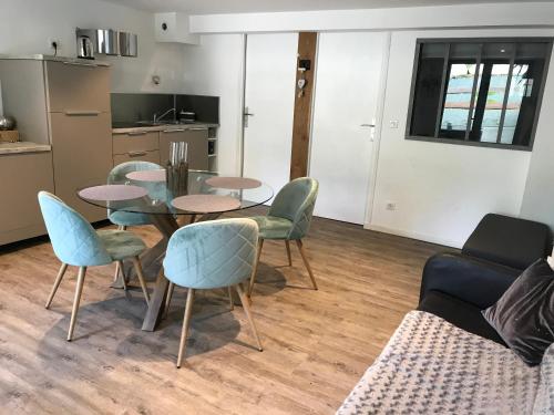 un salon avec une table, des chaises et un canapé dans l'établissement L'hetre, à Saint-Sébastien-sur-Loire