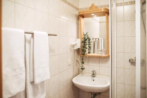 a white bathroom with a sink and a mirror at Restaurant Gästehaus Feldkirchen in Feldkirchen bei Graz