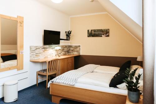 a small bedroom with a bed and a desk at Restaurant Gästehaus Feldkirchen in Feldkirchen bei Graz