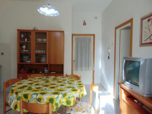 a living room with a table and a tv at N209 - Numana, bilocale con giardino a 100 metri dal mare in Numana