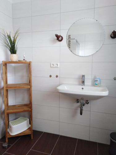 a bathroom with a sink and a mirror at Ferienhaus No.10 in Hemmoor