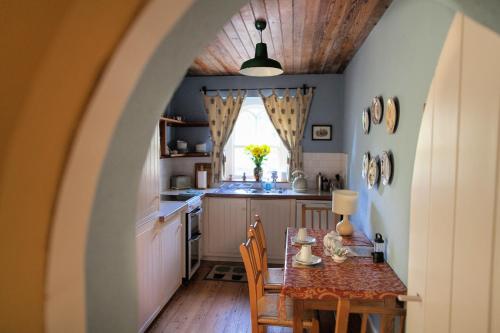 cocina y comedor con mesa y sillas en Anne's Grove Miniature Castle en Castletownroche