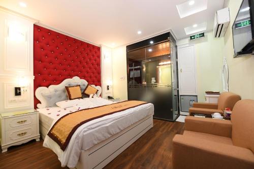 Kawasaki Noi Bai Hotel في Noi Bai: غرفة نوم بسرير كبير وجدار احمر
