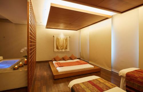 a bedroom with a bed and a tub in a room at Shangri-La Bangkok in Bangkok