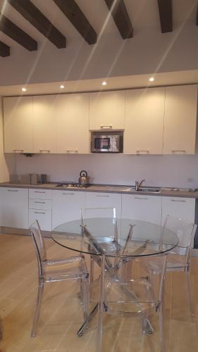 a glass table and two chairs in a kitchen at Ca' Derai in Venice