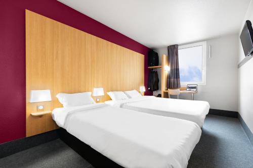 Habitación de hotel con 2 camas grandes y ventana en B&B HOTEL Lyon Vénissieux, en Vénissieux
