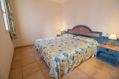 1 dormitorio con 1 cama con edredón azul y blanco en Apartment near the sea with wifi and pool, en Puerto Pollensa