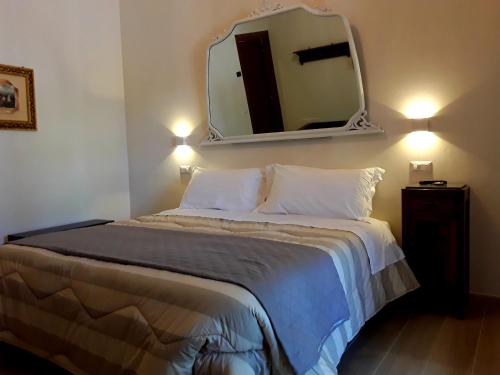 a bedroom with a bed with a mirror on the wall at Suite Umberto I in Assisi