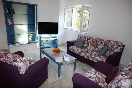a living room with two couches and a tv at Citypark Apartment in Rab