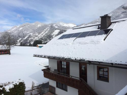 a house with a solar panel on top of a snow covered roof at Ferienwohnung Lassendorf in Hermagor