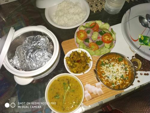 a table with various dishes of food on it at Pratibha Home stay in Jabalpur