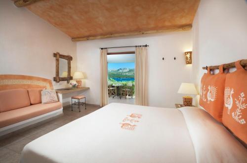 a bedroom with a bed and a couch and a window at Park Hotel & Spa Cala Di Lepre in Palau
