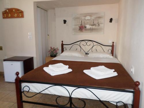 a bedroom with a bed with two towels on it at Tina Hotel in Chania Town