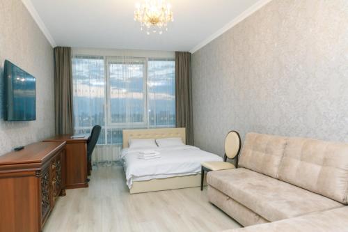 a bedroom with a bed and a couch and a desk at Apart Assistant on Smart Plaza in Kyiv