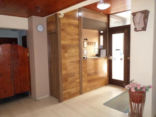 a room with a wooden door with a clock on the wall at Tina Hotel in Chania Town