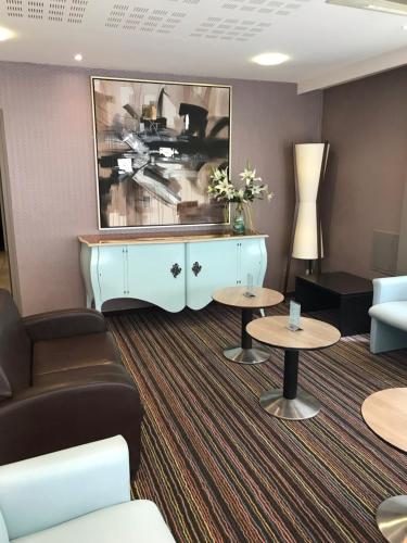 - un salon avec un canapé et une table dans l'établissement Helgon Hotel - Lourdes Pyrénées, à Lourdes