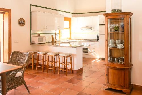 uma cozinha com um balcão e algumas cadeiras e uma mesa em Sa Voliaina em La Savina