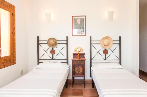 two beds in a room with white walls at Sa Voliaina in La Savina