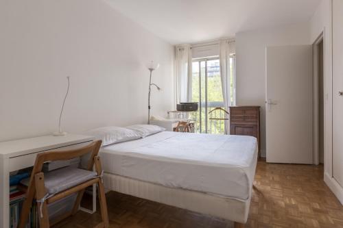 une chambre avec un lit, un bureau et une fenêtre dans l'établissement Veeve - A Pop of Colour, à Paris