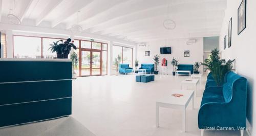 a living room with blue chairs and a table at Hotel Carmen in Venus