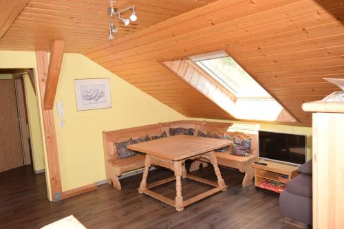 uma sala de estar com uma mesa de madeira e uma janela em Landgasthof Am Teufelstisch em Hinterweidenthal