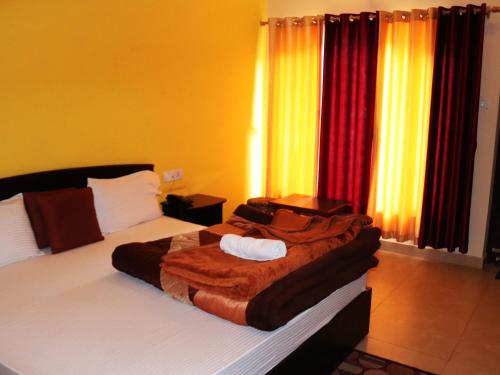 a bedroom with a bed with a blanket on it at Shivalik River Retreat in Almora
