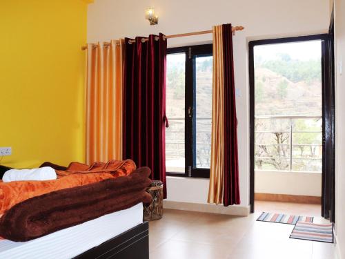 a bedroom with a bed and a large window at Shivalik River Retreat in Almora