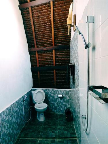 a small bathroom with a toilet and a shower at Green Travelodge Bukit Lawang in Bukit Lawang