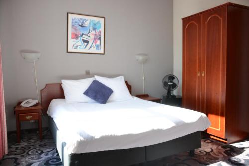 a bed in a bedroom with a white bedspread at Hotel Cathedrale in Tournai
