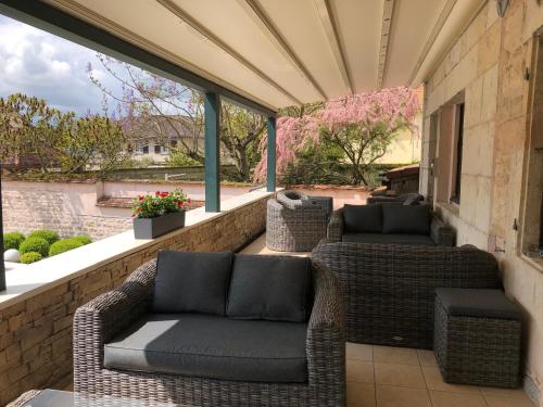 a patio with two wicker chairs and windows at Logis L'Hôtel D'Arc in Arc-sur-Tille