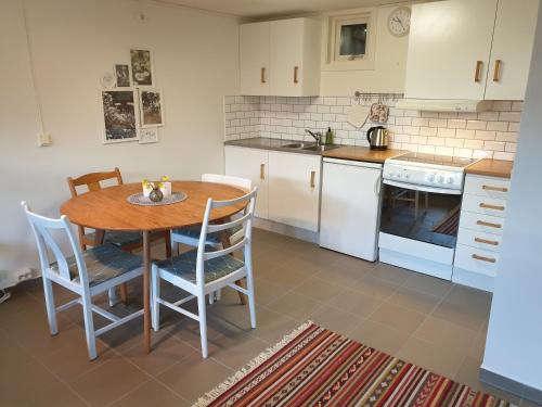 eine Küche mit einem Holztisch und Stühlen in der Unterkunft Stuga Bra Nock in Brösarp
