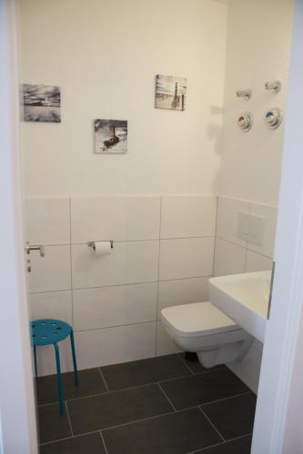 a bathroom with a toilet and a sink and a stool at Ferienwohnung Störtebekersuite in Glowe