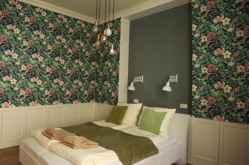 Un dormitorio con una cama con papel pintado floral. en Apartamenty Rudi, en Cracovia
