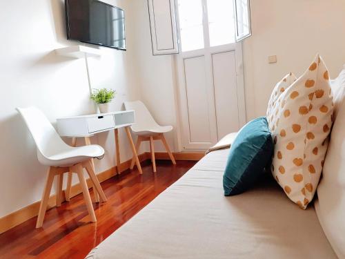 a living room with a bed and a table and chairs at Braga Bells Guesthouse in Braga