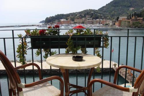 a table with a planter with flowers on a balcony at Hotel Helios in Santa Margherita Ligure