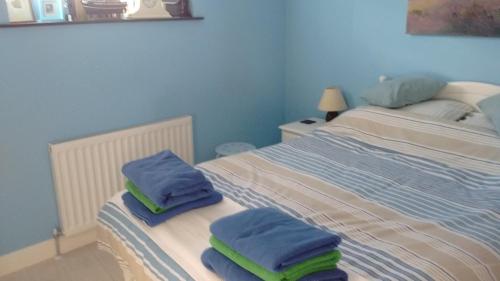 a bedroom with two beds with towels on them at Penzer Cottage in Penzance