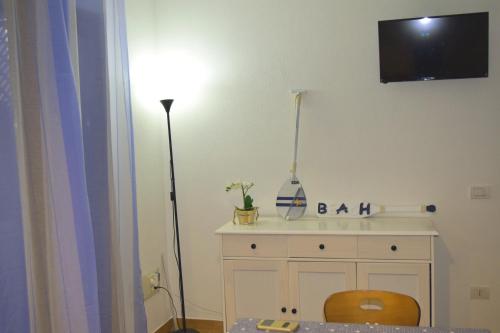 Habitación con tocador y TV en la pared. en IL MARE DI OLBIA Holiday Apartment, en Olbia