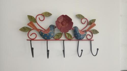 a metal wall decoration with two birds and a flower at Coral Country Homestay in Agra