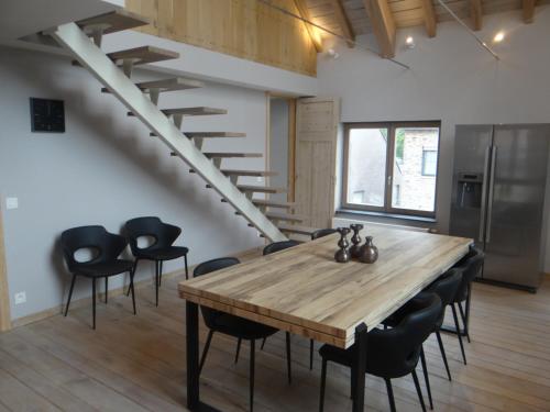 a dining room with a wooden table and black chairs at 't en lande in Alveringem