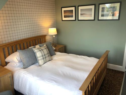 a bedroom with a large white bed with two pillows at The Sunningdale in Bamburgh