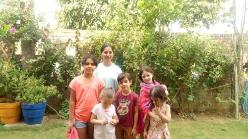 a family posing for a picture in a garden at Coral Country Homestay in Agra