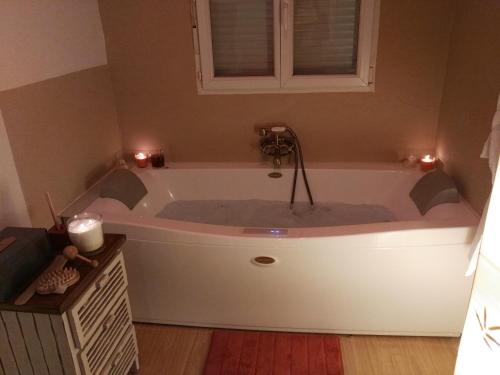 a bath tub in a bathroom with two candles at La Casita in Partida de La Cañada