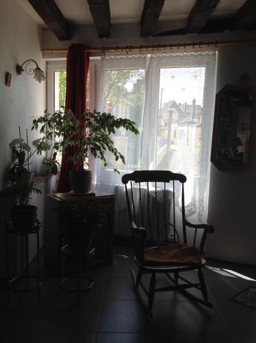 - un fauteuil à bascule dans une chambre avec fenêtre dans l'établissement Chambre chez l'habitant au centre ville, à La Flèche